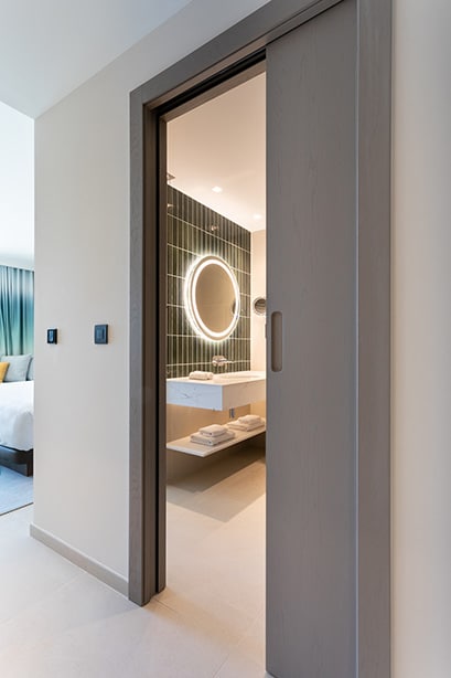 Sliding bathroom door solution installed within a Hard Rock Hotel Malta guest room by Construct Furniture.